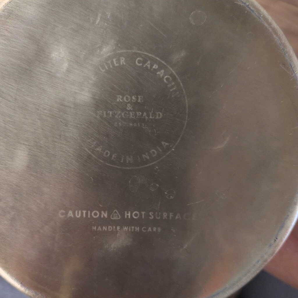 Metallic container with 'Rose & FitzGerald' branding and text on a blurred background