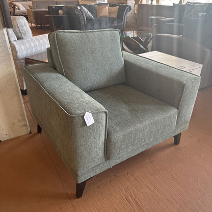 Gray armchair with a tag in a furniture store setting