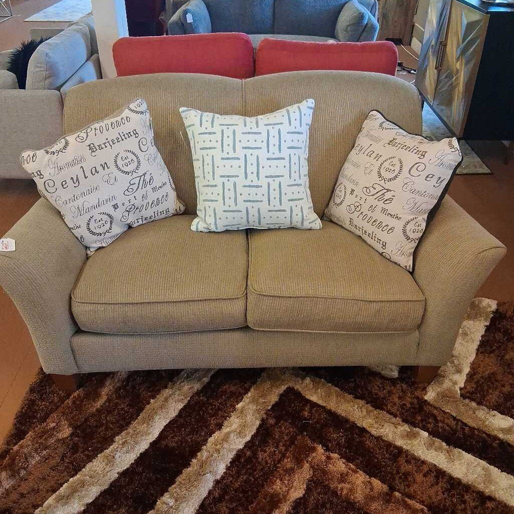 Beige sofa with decorative pillows on a patterned rug