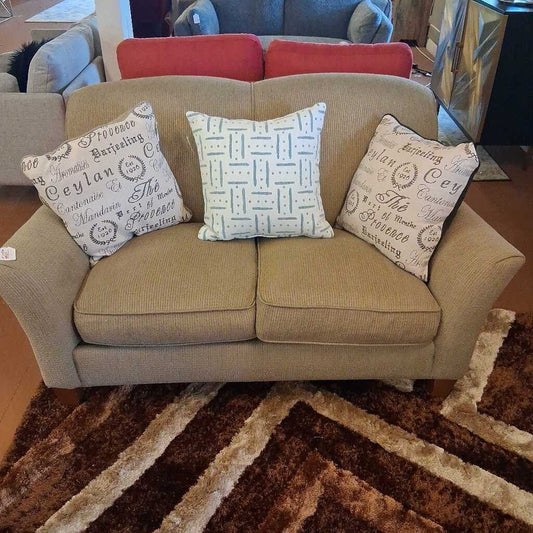 Beige sofa with decorative pillows on a patterned rug