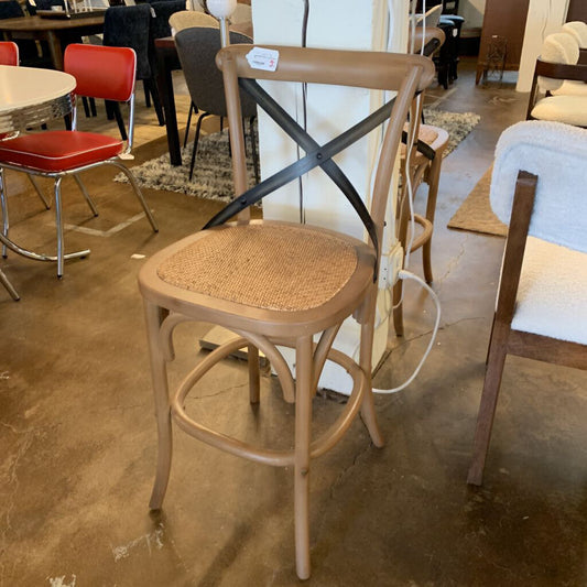 Wooden bar stool with wicker seat in a showroom setting
