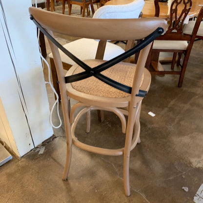 Wooden chair with a woven seat and metal cross-back in a room with other furniture.
