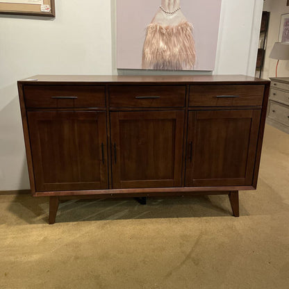 Wooden sideboard in a room with a painting on the wall
