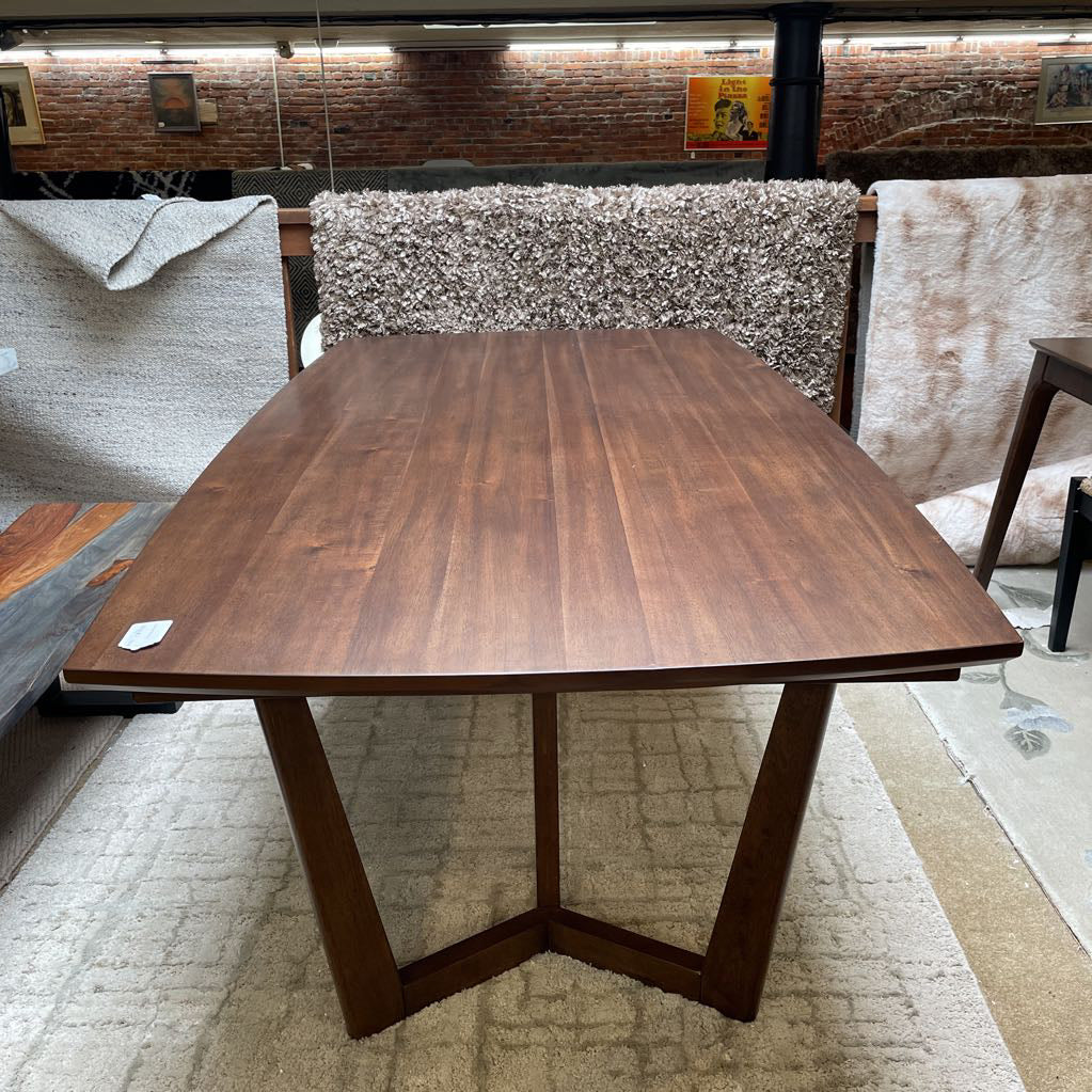 Wooden dining table with chairs in a storage or warehouse setting