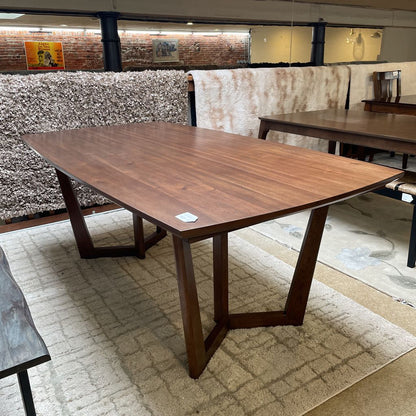 Wooden dining table with chairs in a storage or warehouse setting