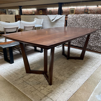 Wooden dining table with chairs in a storage or warehouse setting