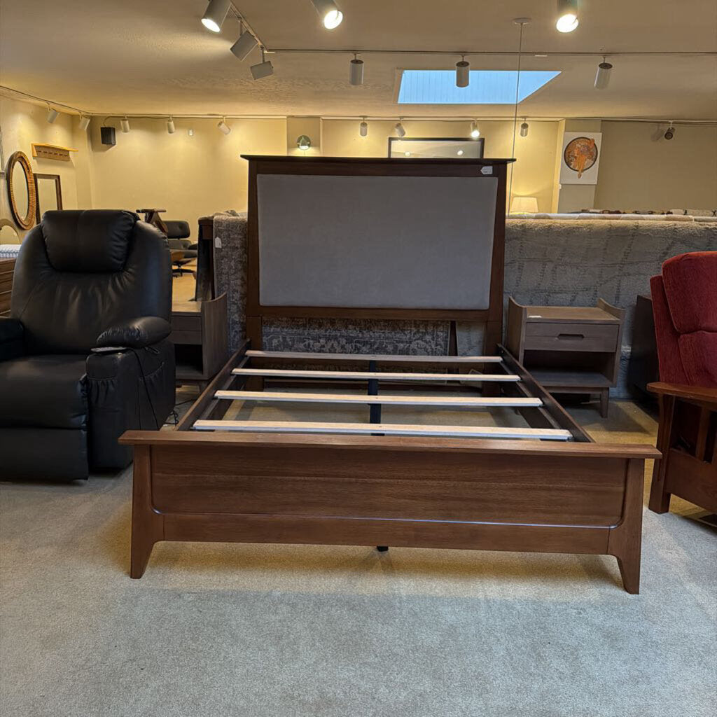 Wooden bed frame in a room with furniture and decor