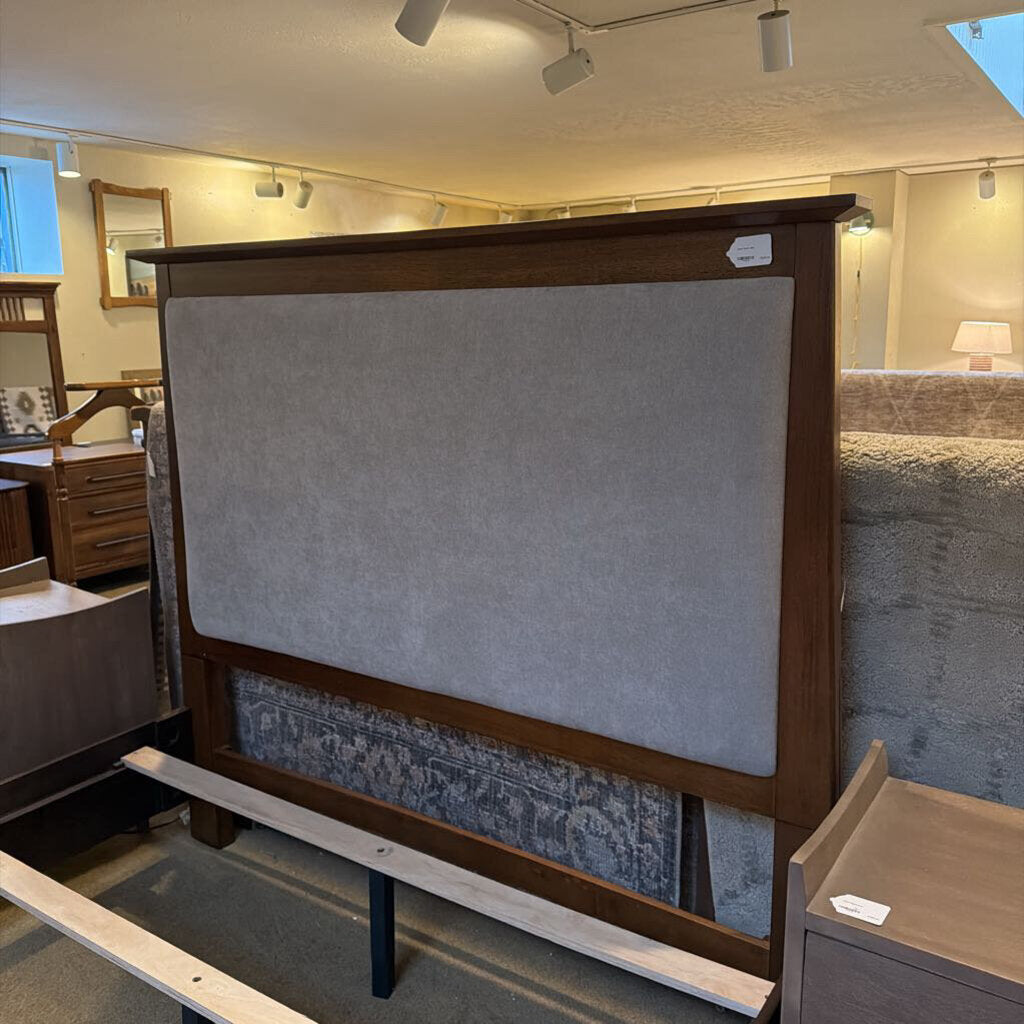 Wooden headboard with upholstered panel in a furniture store setting