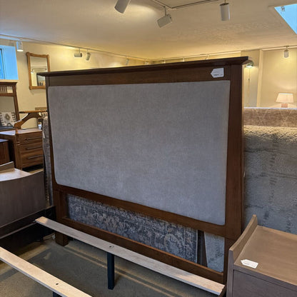 Wooden headboard with upholstered panel in a furniture store setting