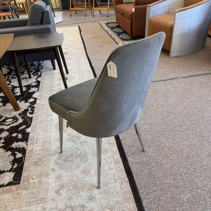 Gray chair with a tag on a patterned rug in a furniture store
