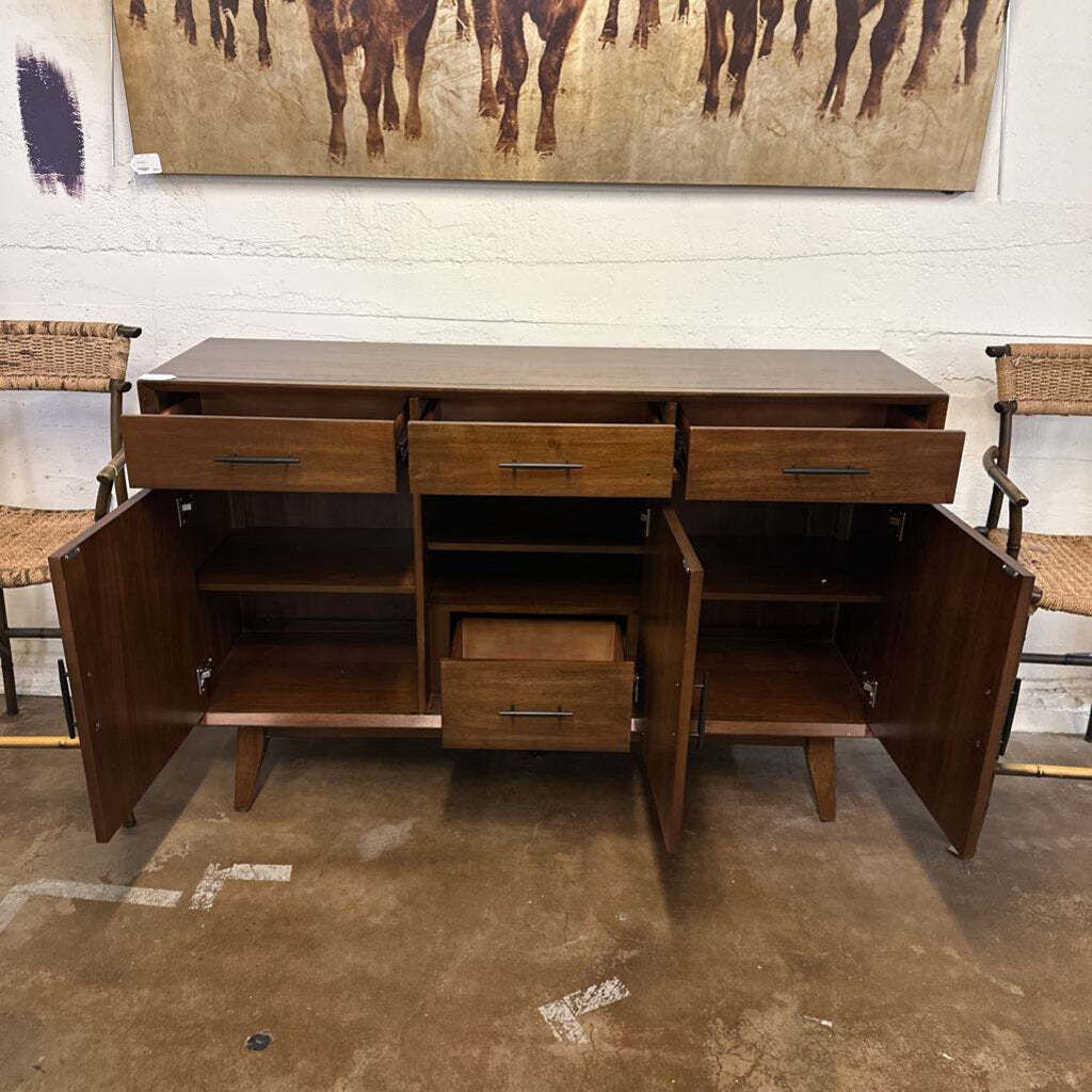 Wooden sideboard with open doors in a room with chairs and a painting on the wall.