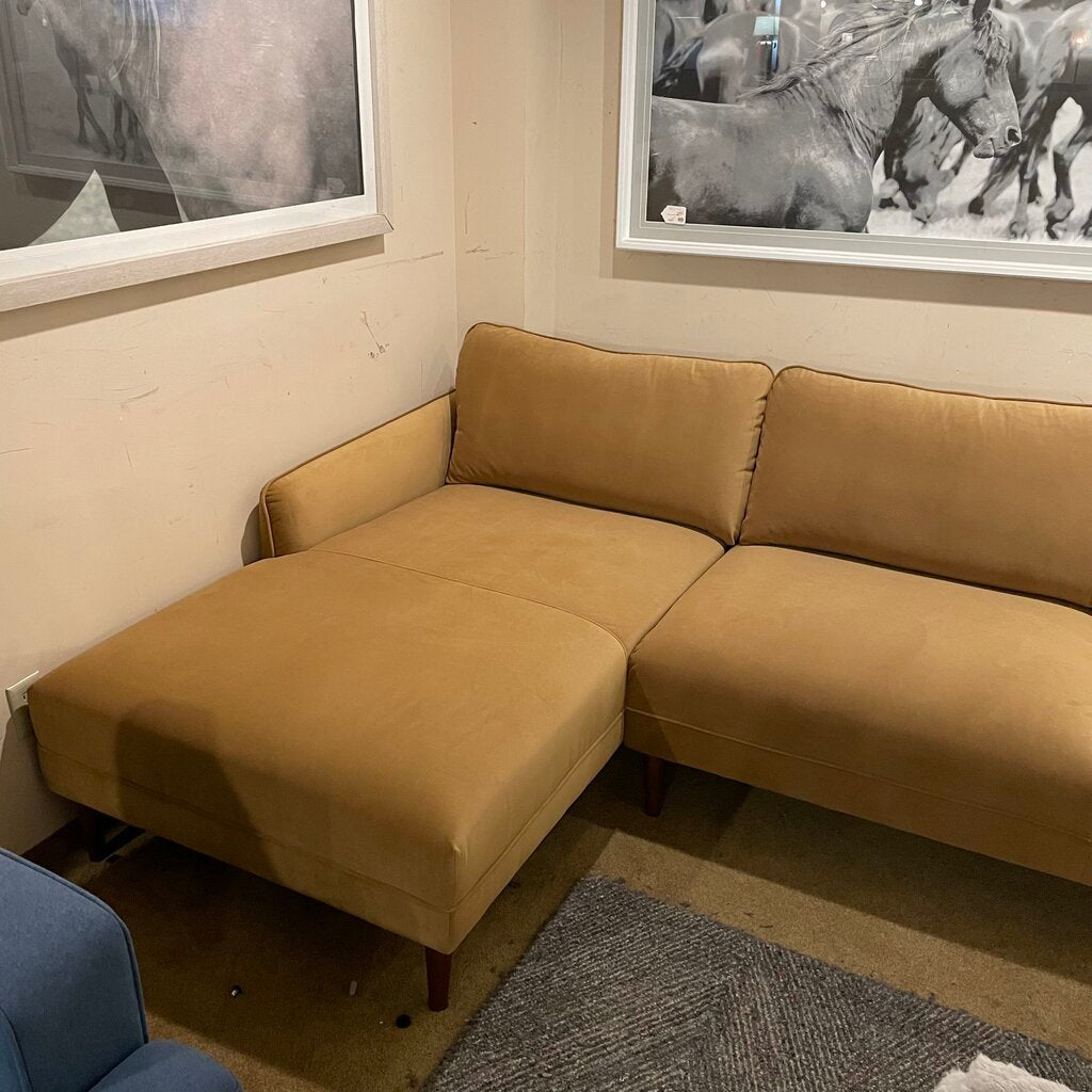 Brown sectional sofa in a room with horse artwork on the walls.