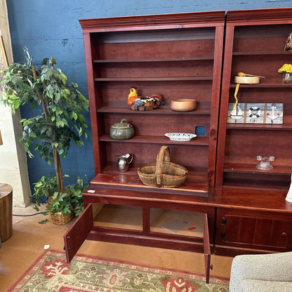 Wooden bookshelf with decorative items against a blue wall