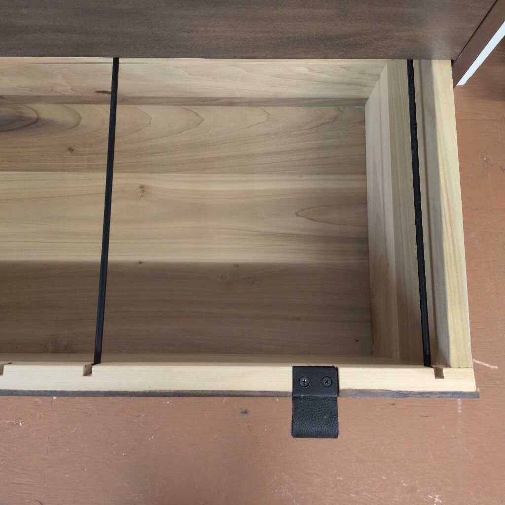 Wooden drawer with a black handle on a wooden surface