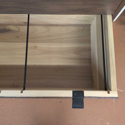 Wooden drawer with a black handle on a wooden surface