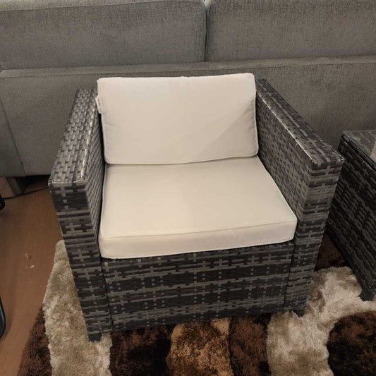 Wicker chair with white cushion in a living room setting