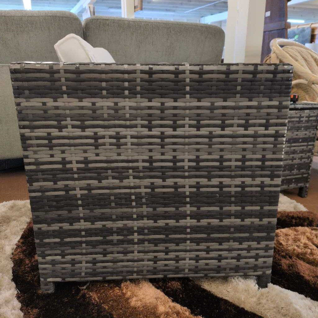 Woven basket with a checkered pattern on a carpeted floor.