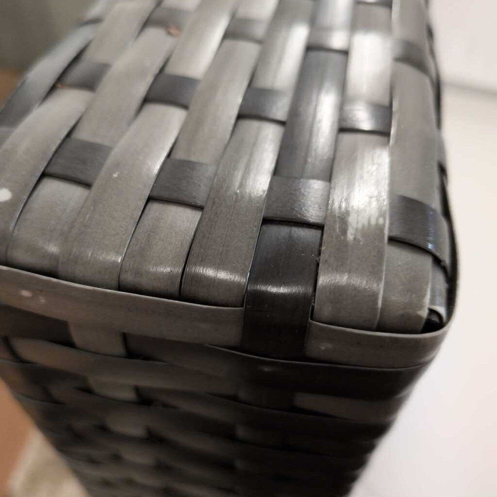 Close-up of a woven basket with gray and black bands.