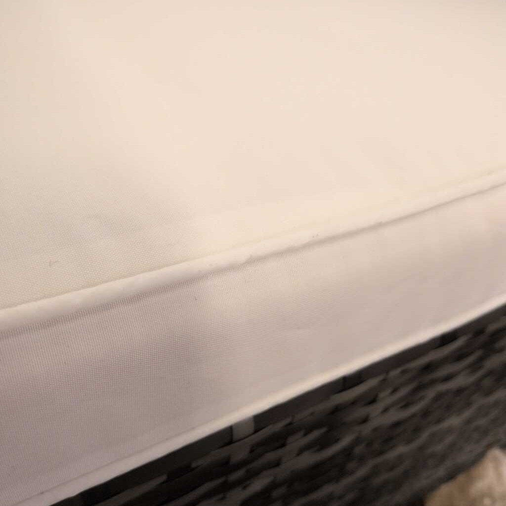 Close-up of a textured white surface with a black object partially visible.