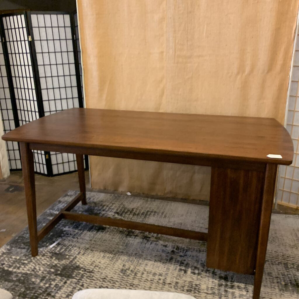 Wooden table in a room with a textured wall and rug