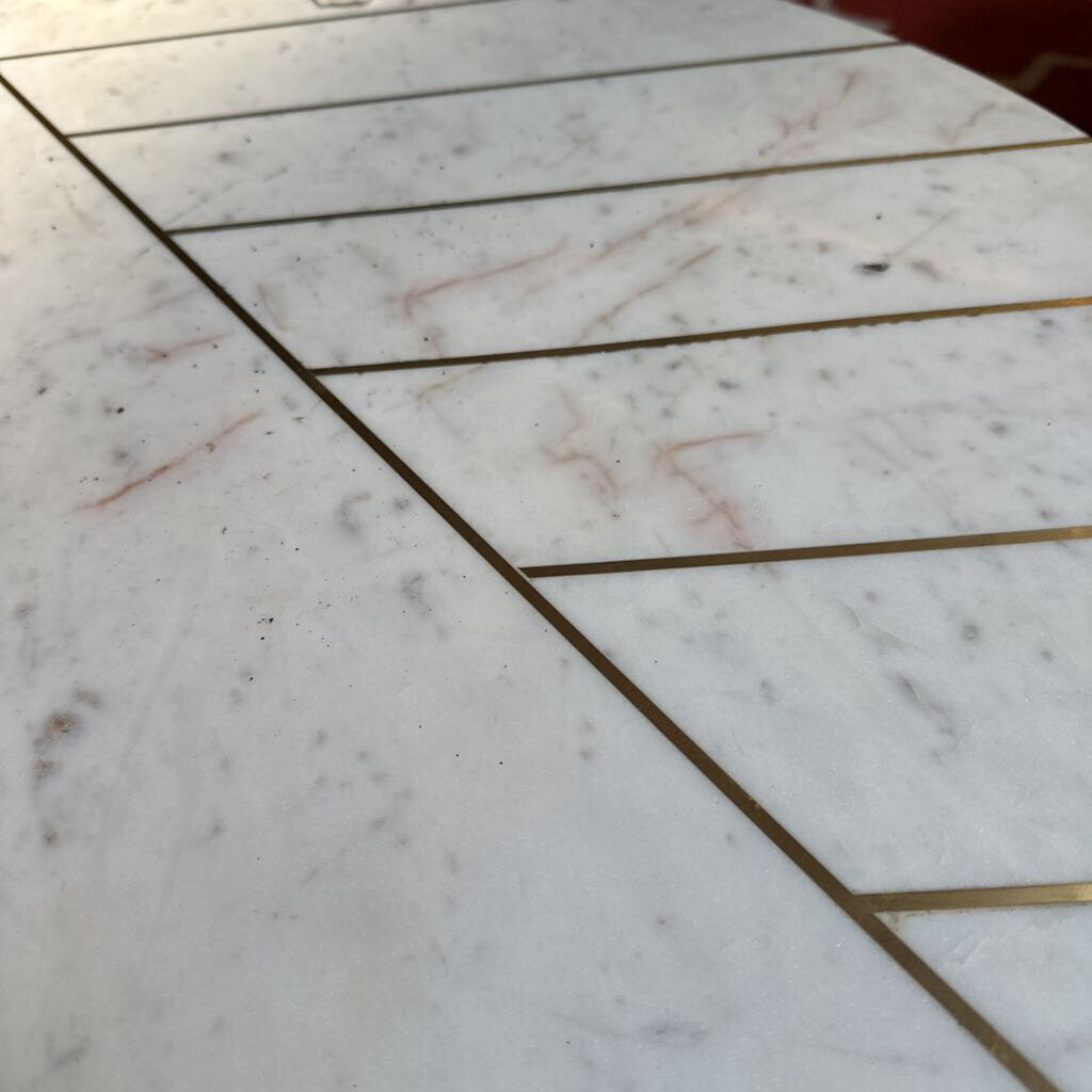 Close-up of a marble floor with gold grout lines