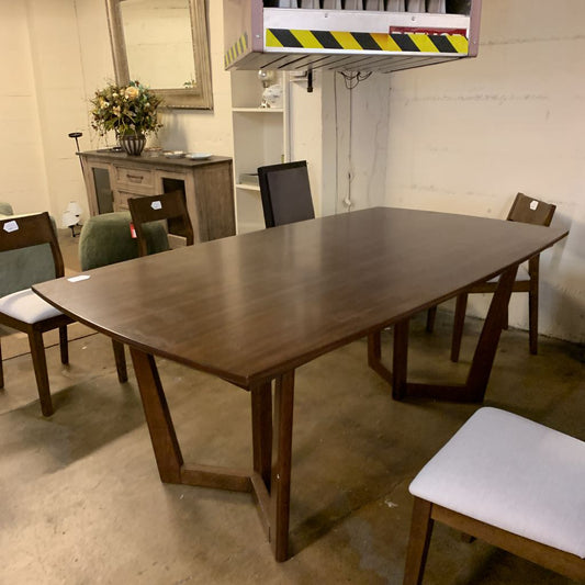 Wooden dining table with chairs in a storage or warehouse setting