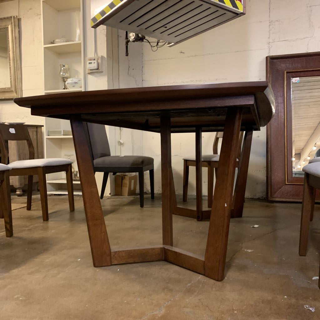 Wooden dining table with chairs in a storage or warehouse setting