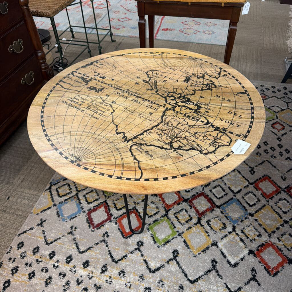 Round wooden table with world map design on a patterned rug