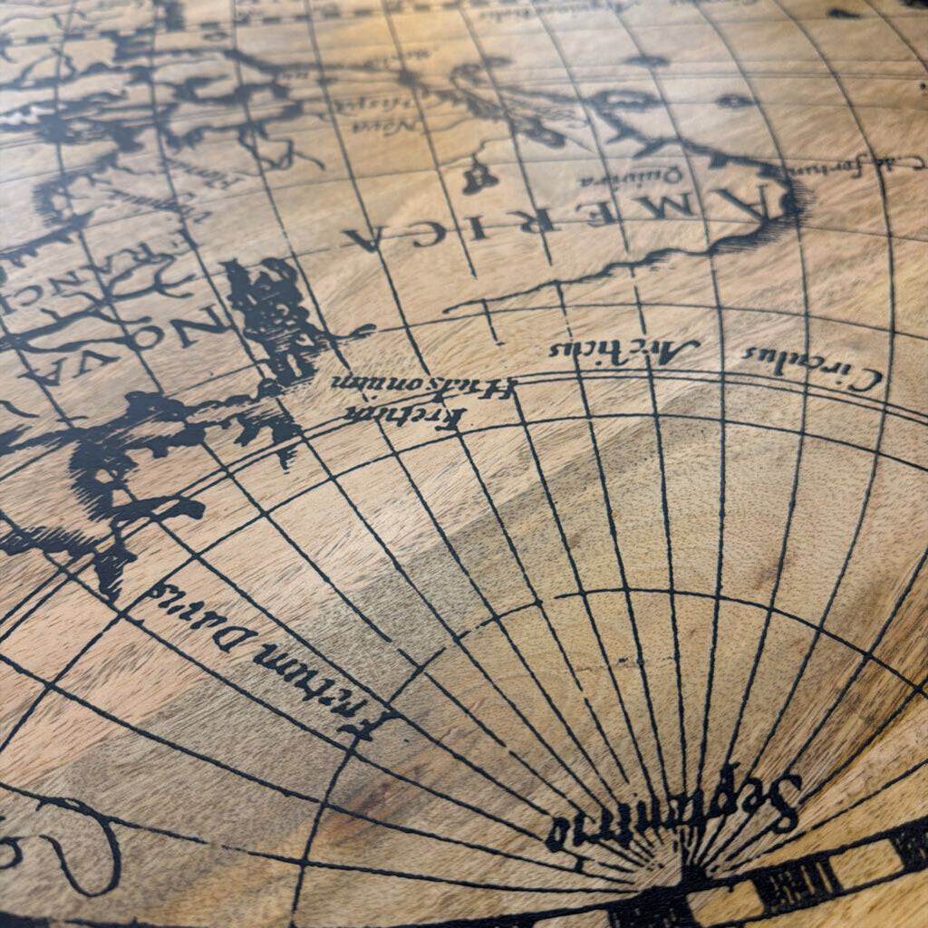 Close-up of an old map with detailed lines and text on a wooden surface.