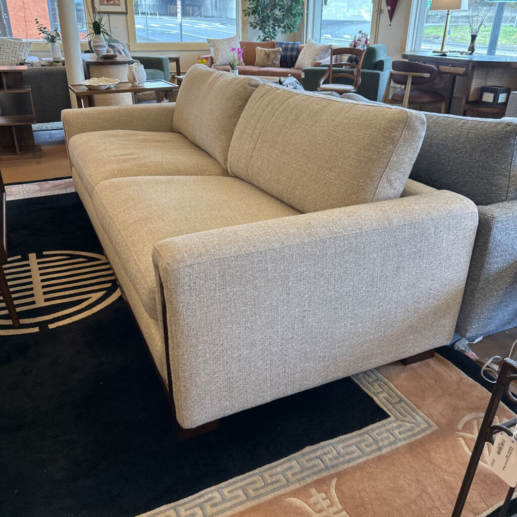 Beige sofa in a room with a rug and furniture