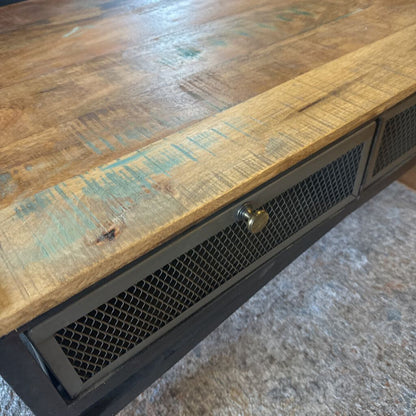 Wooden table with metal frame and decorative elements on a textured surface