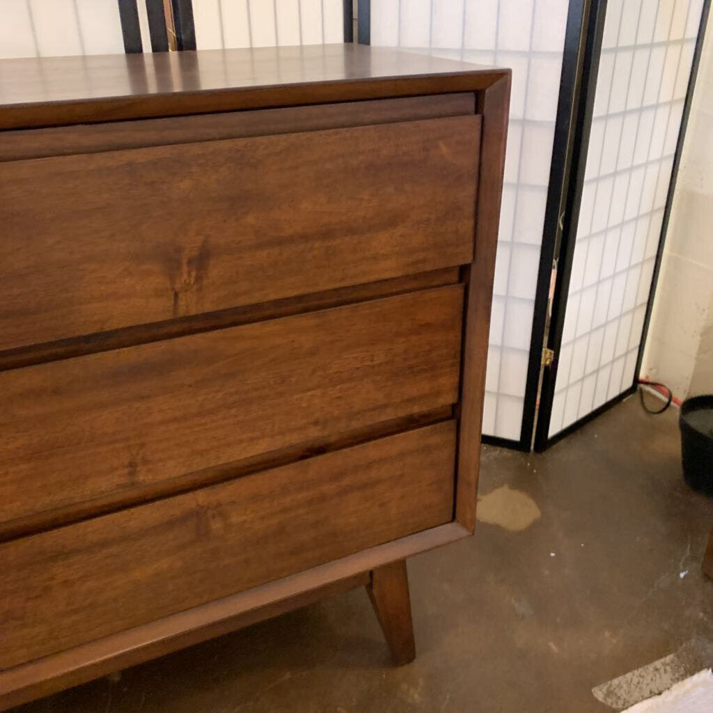Wooden dresser with three drawers in a room setting.