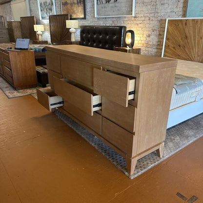 Wooden dresser with open drawer in a furniture store setting