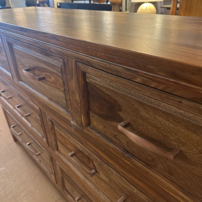 Wooden dresser with multiple drawers and a smooth finish.