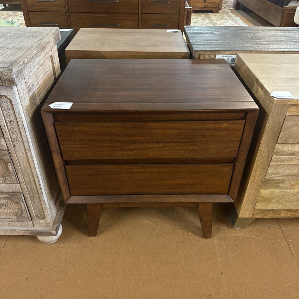 Wooden nightstand with two drawers in a furniture store setting