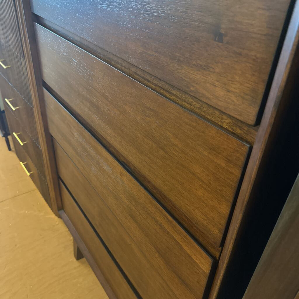 Wooden dresser with multiple drawers on a plain background