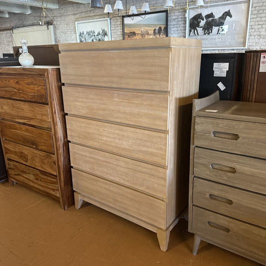Wooden dresser with multiple drawers in a showroom setting