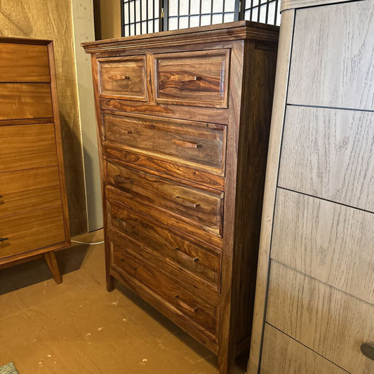 Wooden dresser with multiple drawers in a room setting