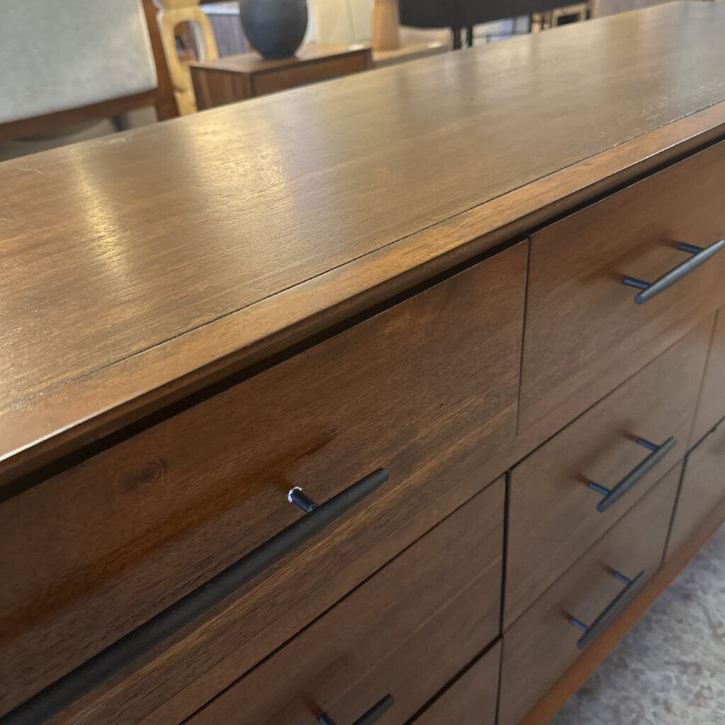 Wooden dresser with metal handles in a room setting