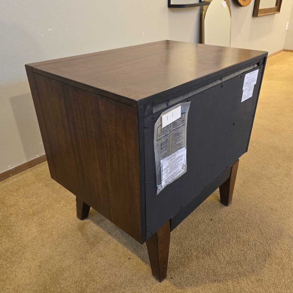 Wooden side table with a dark finish on a carpeted floor.