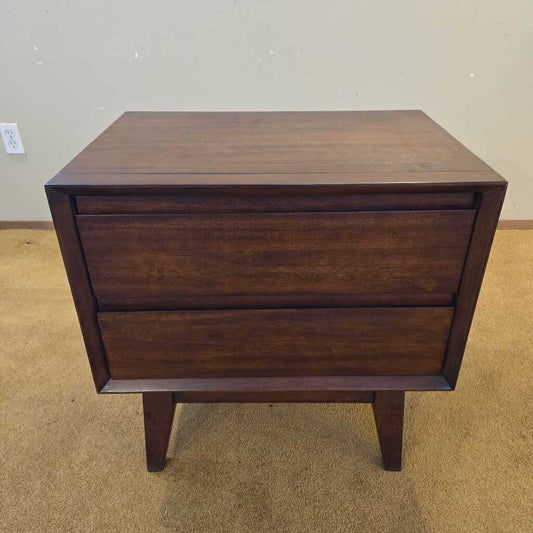 Wooden nightstand with two drawers on a plain background