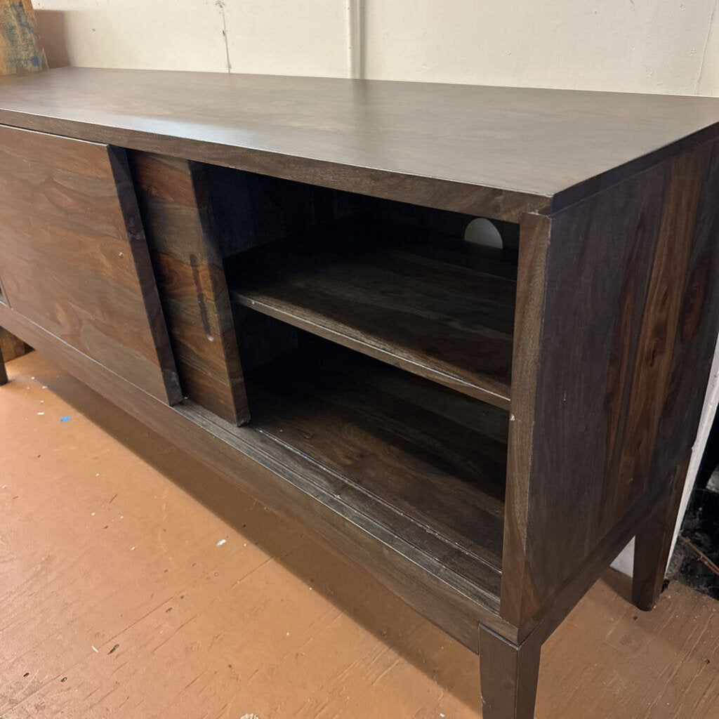 Wooden sideboard with open shelves on a wooden floor.
