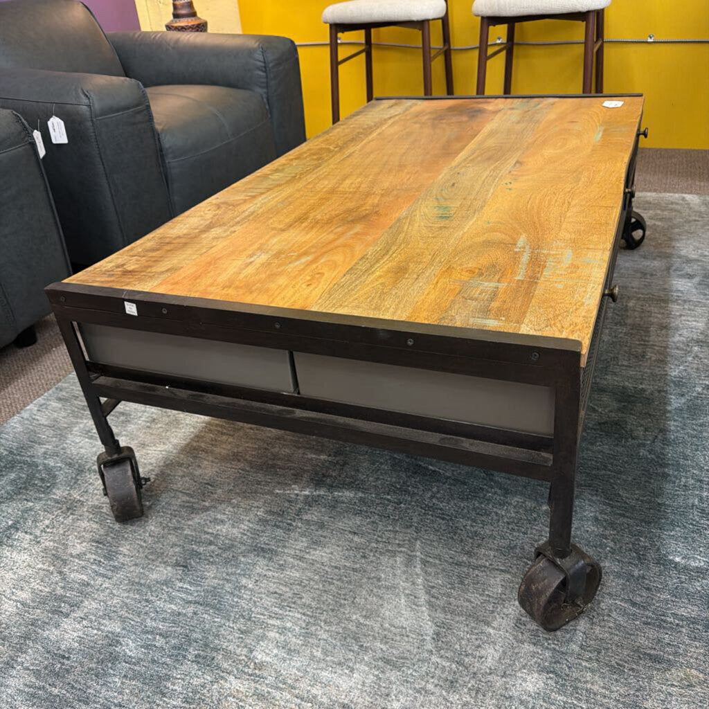 Wooden coffee table with metal frame and wheels in a room setting