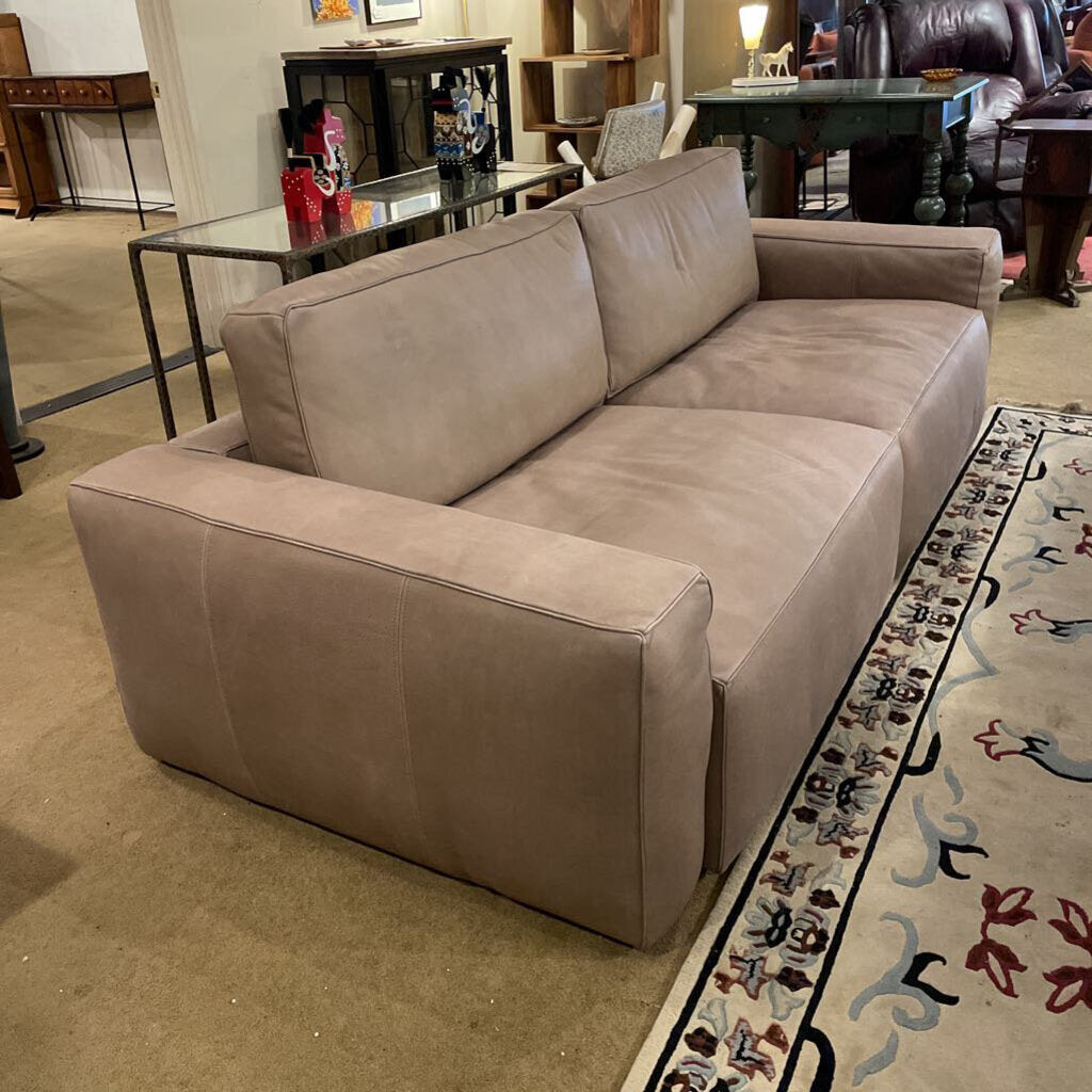 Beige sectional sofa in a room with a patterned rug and furniture.