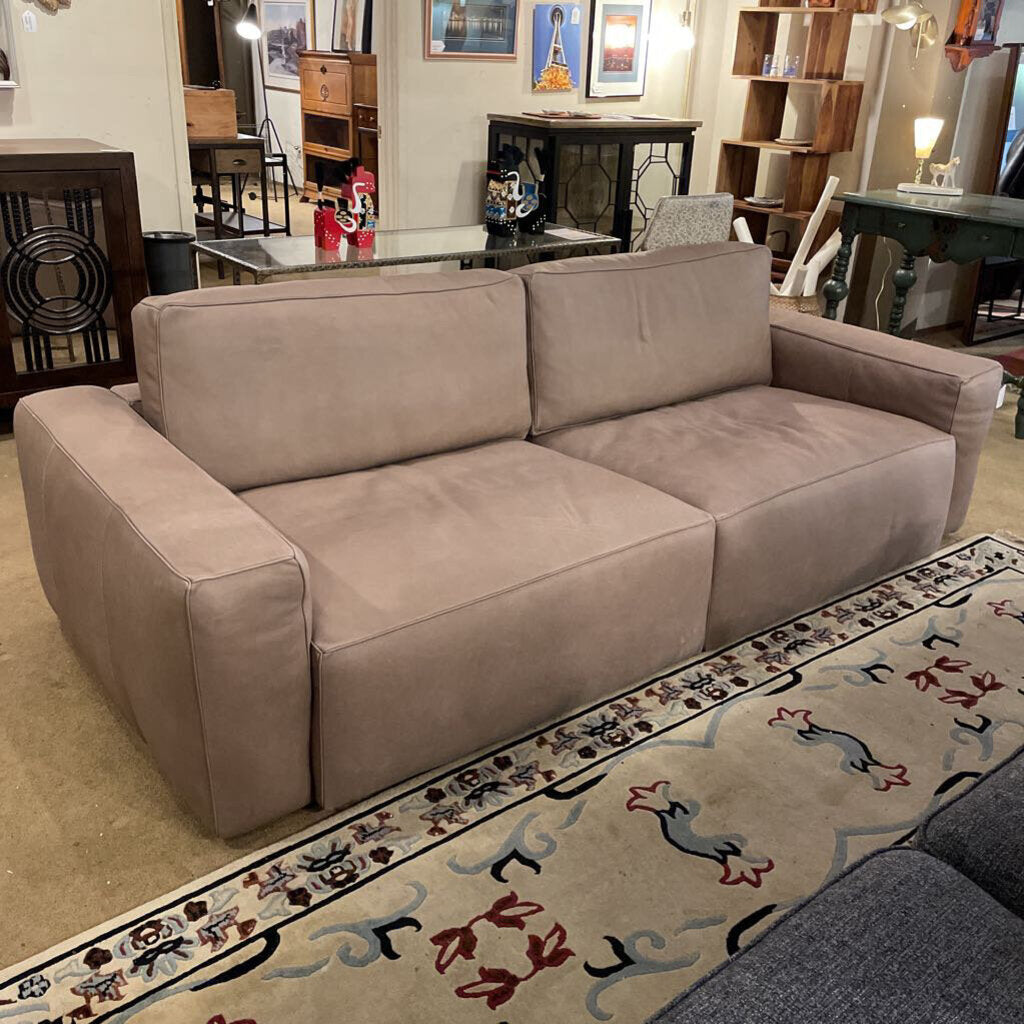 Beige sofa in a room with furniture and decor