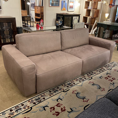 Beige sofa in a room with furniture and decor