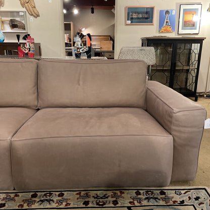 Brown sectional sofa in a room with decor and furniture.