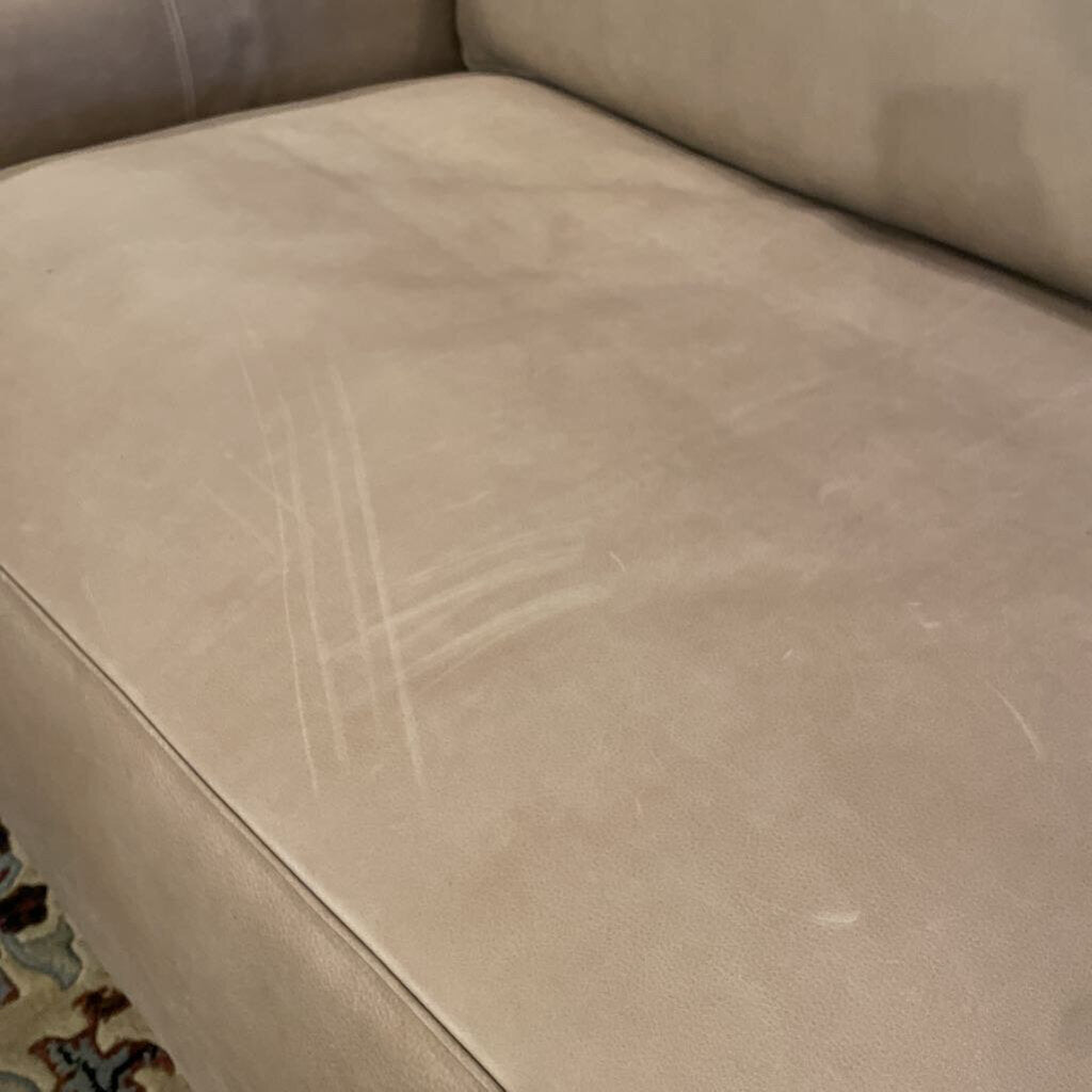 Beige sofa with visible wear and tear