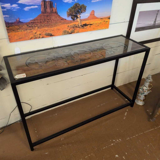 Console table with decorative elements against a wall with a scenic painting