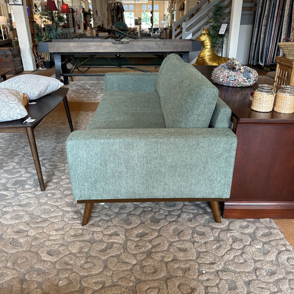 Green armchair in a room with furniture and decor